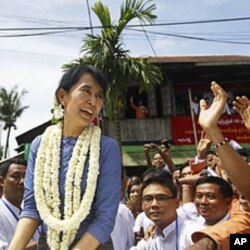 Aung San Suu Kyi, leader of Burma's democratic opposition, smiles to supporters near Bago, some 100 km north of Rangoon, August 14, 2011