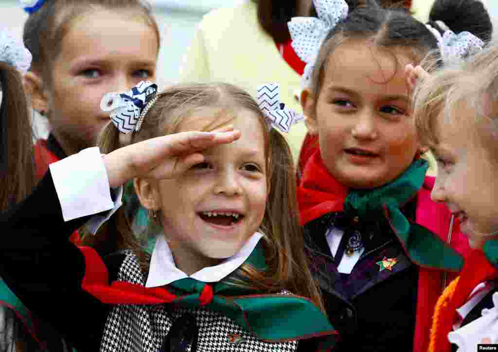 A Belarusian schoolgirl salutes during celebrations commemorating the 27th anniversary of the country's Young Pioneer movement in Minsk.