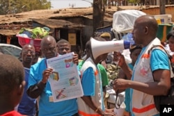 Các nhân viên y tế dạy người dân về virut Ebola và cách phòng tránh lây nhiễm tại Conakry, Guinea