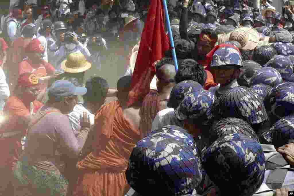 Para mahasiswa yang telah berdemonstrasi sejak 3 Maret mencoba mendorong blokade polisi di Letpadan, Myanmar (10/3). (​AP/Khin Maung Win)