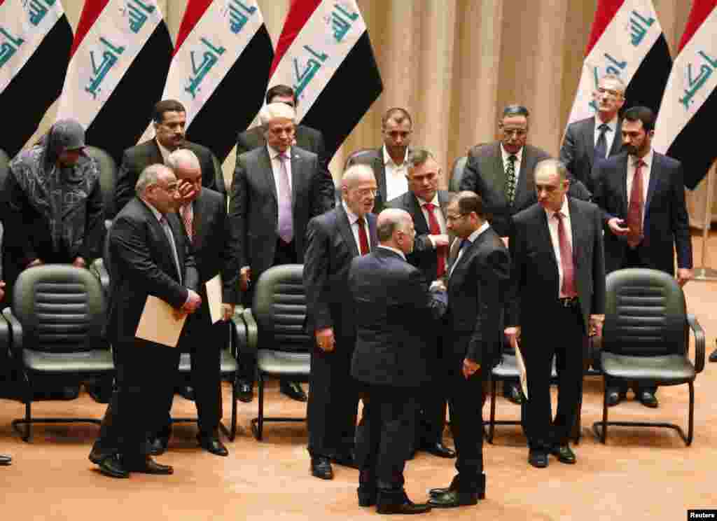 Members of the incoming Iraqi cabinet speak to one another during a parliamentary session to vote on Iraq&#39;s new government at the parliament headquarters in Baghdad, Sept. 8, 2014.