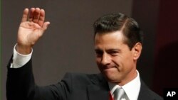 Mexican President Enrique Pena Nieto waves to supporters after delivering his sixth and final State of the Nation address at the National Palace in Mexico City, Sept. 3, 2018.