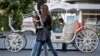 Girls walk past a carriage in Odessa, Ukraine, May 7, 2014. 