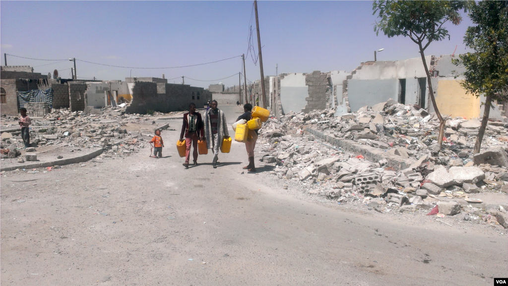 These men walk about one-half kilometer to the nearest water provided by a local charity, Sana'a, Oct. 9, 2015. (Almigdad Mojalli/VOA)