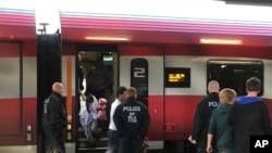 German police pull migrants off a train from Budapest and Vienna as part of new border control measures meant to ease the pressure on Munich, until now the main entry point for migrants reaching Germany, Sept. 14, 2015. (L. Ramirez/VOA)
