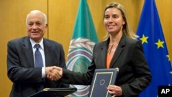 Secretary General of the Arab League Nabil Al-Araby, left, shakes hands with European Union High Representative Federica Mogherini after signing a cooperation agreement following a meeting of EU foreign ministers in Brussels, Jan. 19, 2015. 