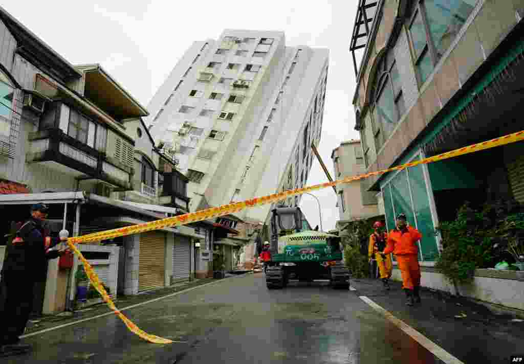 امدادگران در نزدیکی ساختمانی که بر اثر زمین لرزه&nbsp;در تایوان فرو ریخته،&nbsp; مشغول کار هستند. &nbsp;
