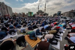 Orang-orang berdoa di luar Masjid Taksim yang baru dibangun di Taksim Square di Istanbul, Jumat, 28 Mei 2021. (Foto: AP)