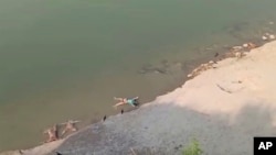 Mayat-mayat tampak mengambang di Sungai Gangga di Uttar Pradesh, India Selasa (11/5).