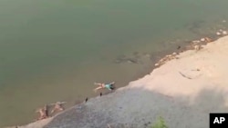 这张从KK Productions 2021年5月11日拍摄的视频截图显示一些死者遗体被放在河边。恒河上发现了被水冲下的数十具遗体。(KK PRODUCTIONS via AP)