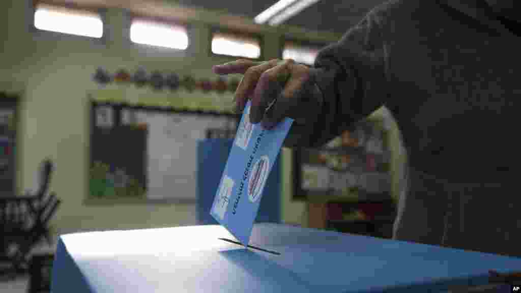 Un homme place son bulletin de vote dans l'urne lors des élections législtaives à Tel Aviv, Israel, le 17 mars 2015.