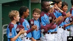 Philadelphia pitcher Mo'ne Davis, second from left, stands with her teammates at the Little League World Series tournament in South Williamsport, Pa., Friday, Aug. 15, 2014. 