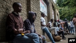 Des migrants du Zimbabwe et du Mozambique sont assis dans une rue de Johannesbourg, en Afrique du Sud, le 23 novembre 2017.