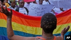 FILE - People protest against the sentencing of two men in Malawi under Malawi's anti-gay legislation in Cape Town, South Africa, May 20, 2010. Two Kenyan men have filed a constitutional petition against forced anal examinations to "prove homosexuality."