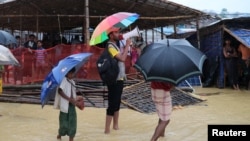 FILE - A volunteer of Bangladesh Red Crescent Society speaks to the Rohingya refugees who have missing relatives in Myanmar or other countries, in Kutupalong camp, in Cox's Bazar, Bangladesh, July 4, 2018. 