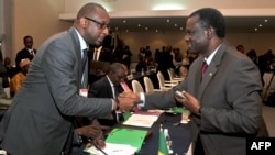 President of ECOWAS) Desire Kadre Ouedraogo (R), greets Malian Foreign Minister Tieman Coulibaly on Sept. 17, 2012 in Abidjan