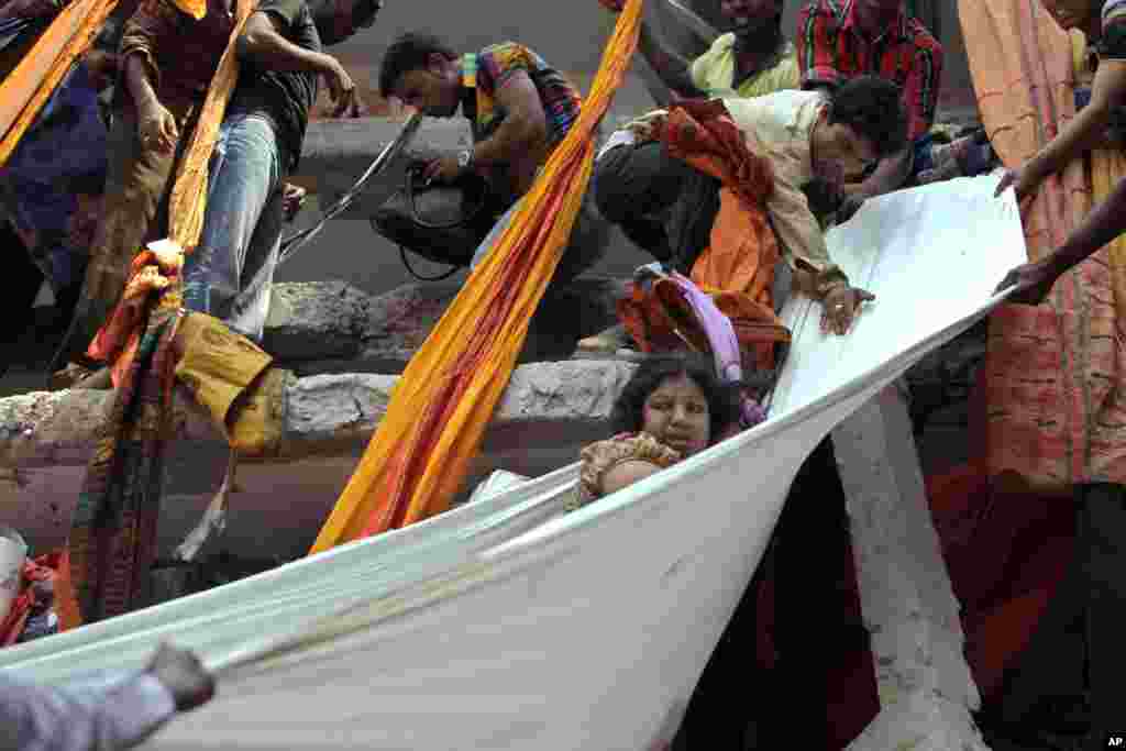 Regu penolong menggunakan potongan-potongan kain untuk menurunkan korban yang selamat dari ambruknya gedung bertingkat delapan di Savar, dekat Dhaka, Bangladesh, 24 April 2013.