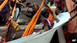 Les secouristes utilisent du tissu pour évacuer le survivants de l'effondrement d'un immeuble à Savar au Bangladesh le 24 avril 2013