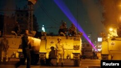 Egyptian Army soldiers stand guard on a road near the presidential palace as supporters of deposed president Mohamed Morsi approach, in Cairo, July 19, 2013.