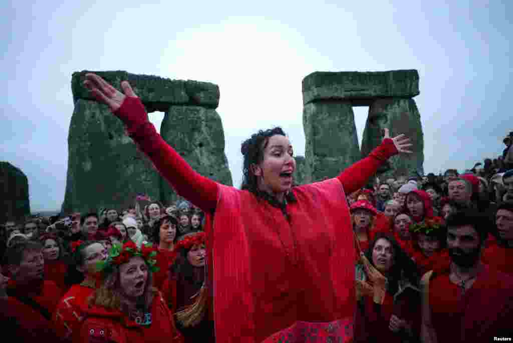 People celebrate as the sun rises during the winter solstice at Stonehenge on Salisbury Plain in southern England, Britain.