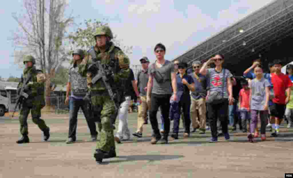 Members of Japan's Ground Self Defense Force escort Japanese "evacuees" to an aircraft during Cobra Gold 2015. (Steve Herman/VOA News)