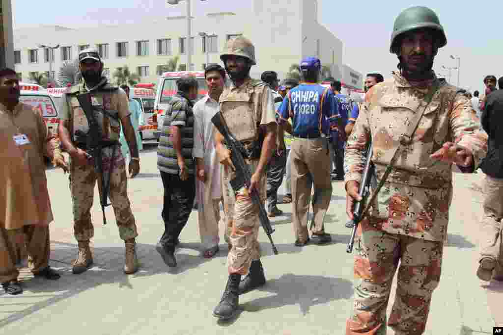 Pakistani paramilitary troops stand guard outside a local hospital following an attack on a bus in Karachi, May 13, 2015.