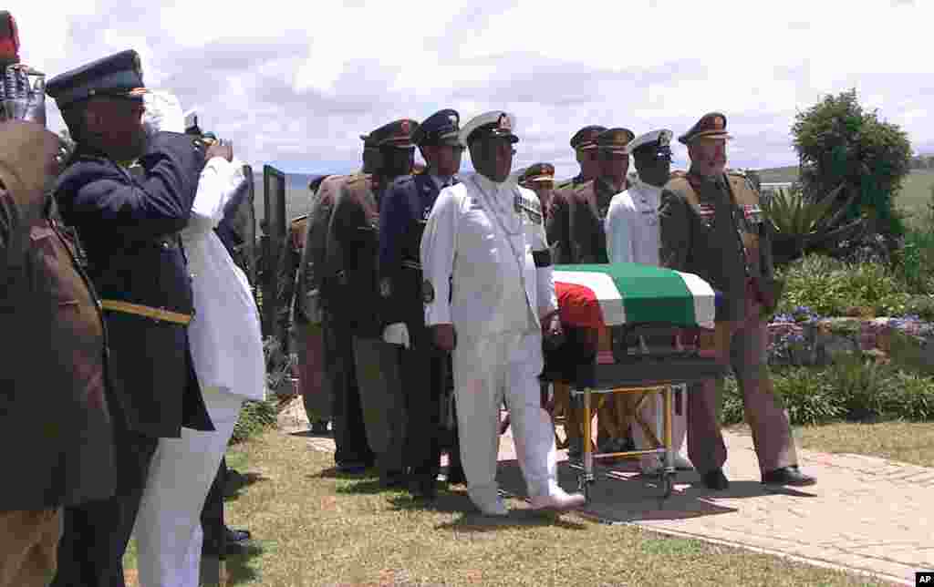 Di foto ini, petugas militer mengawal peti mati mantan presiden Afrika Selatan Nelson Mandela ke lokasi pemakaman setelah upacara pemakaman di Qunu, Afrika Selatan, 15 Desember 2013.
