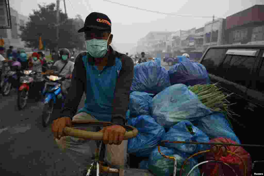 A street vendor is seen wearing a face mask in Dumai, Indonesia, June 21, 2013. 