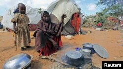 Kadija Mohamed cooks food for her children in a camp set up for internally displaced people in Dinsoor, in southern Somalia, January 5, 2012.