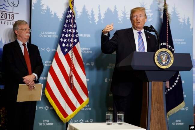 National Security Adviser John Bolton looks on as President Donald Trump speaks during a news conference at the G-7 summit, June 9, 2018, in La Malbaie, Quebec, Canada.