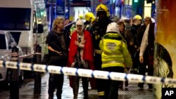 Một phụ nữ (giữa) được nhân viên cứu cấp băng bó sau khi tai nạn xảy ra tại nhà hát Apollo ở London, 19/12/13