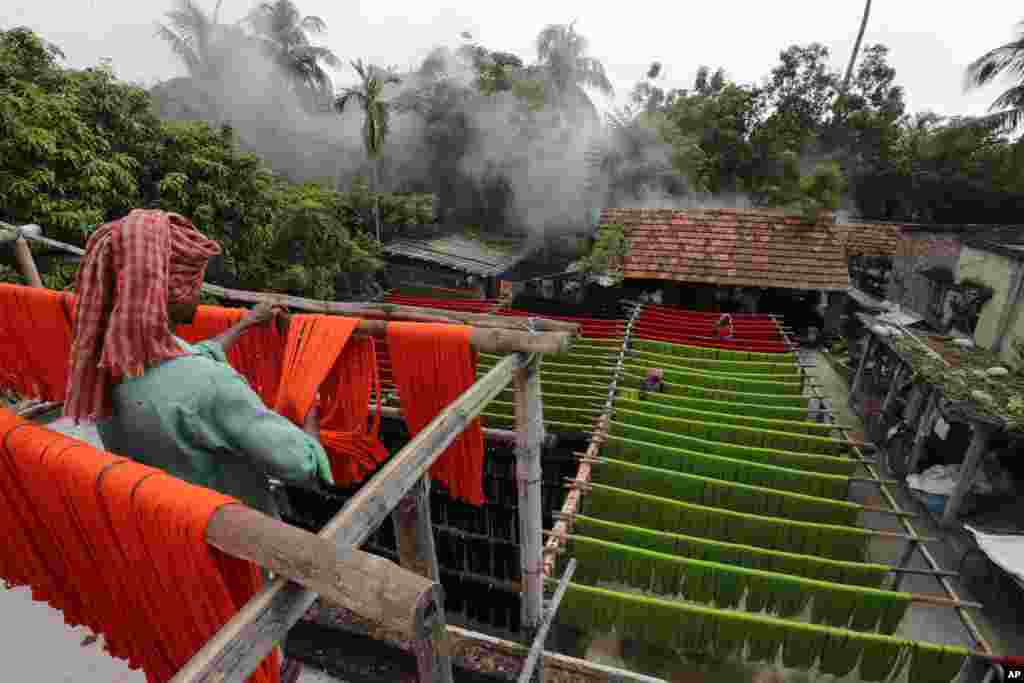 Laborers hang colored yarn to dry in Santipur, about 120 kilometers north of Kolkata, India. 