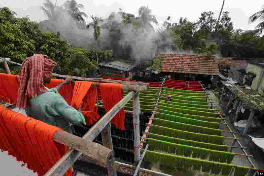 Laborers hang colored yarn to dry in Santipur, about 120 kilometers north of Kolkata, India.&nbsp;