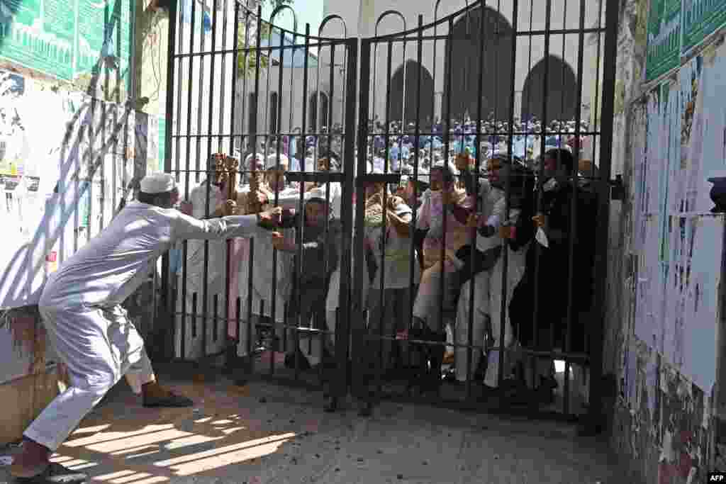 Protesters try to break a locked gate of the National Mosque during a demonstration after the Friday prayers in Dhaka, Bangladesh.