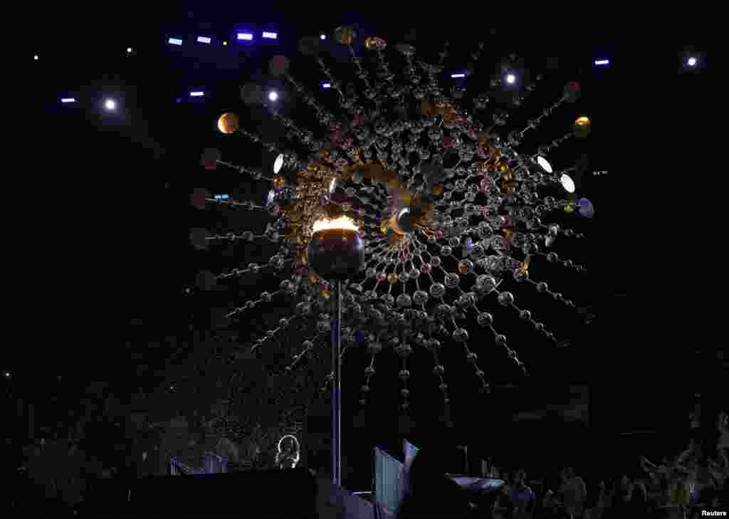 Brazilian singer Mariene de Castro sings as rain extinguishes the Olympic flame during the closing ceremony in Rio de Janeiro, Brazil, Aug. 21, 2016.