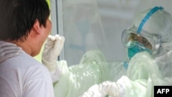 ရန်ကုန်မြို့ရှိ Quarantine စင်တာတခုမှာ swab နမူနာယူနေတဲ့ ကျန်းမာရေးဝန်ထမ်းတဦး။ (မေ ၁၆၊ ၂၀၂၀)
