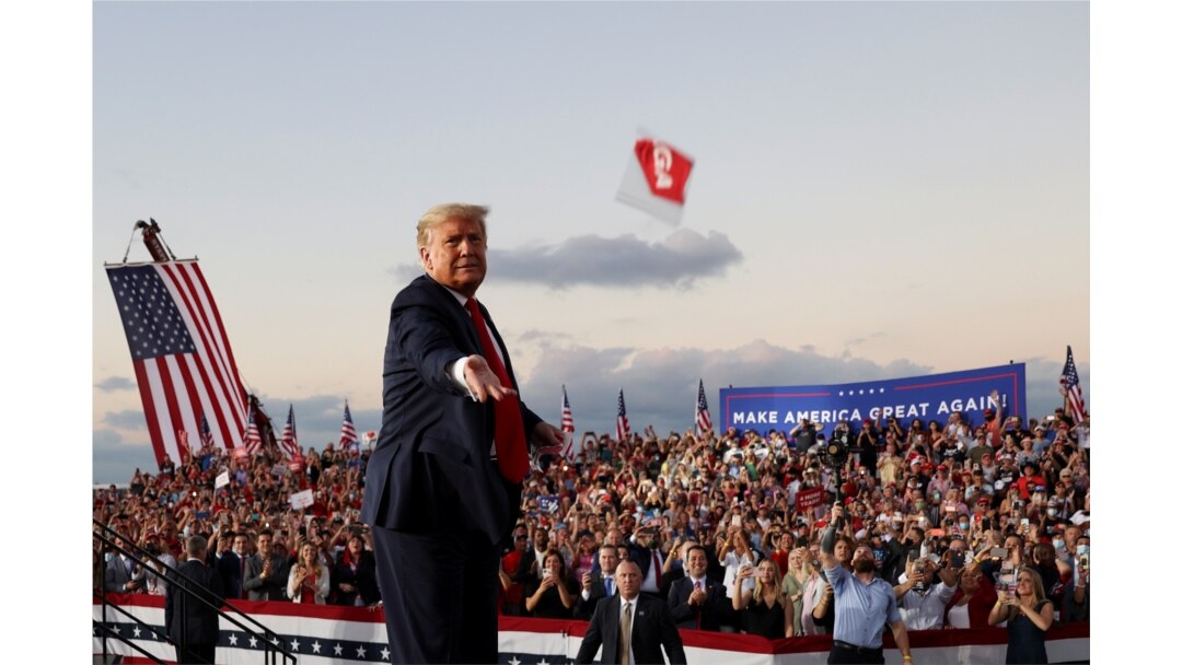 Presiden AS Donald Trump melempar masker dari panggung dalam kampanye pertamanya sejak dirawat karena terinfeksi virus corona (COVID-19) di Bandara Internasional Orlando Sanford di Sanford, Florida, Senin, 12 Oktober 2020. (Foto: Reuters)