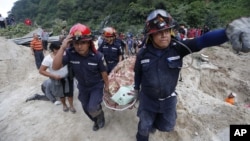 Rescue workers carry a body away from the site of a landslide in Santa Catarina Pinula, on the outskirts of Guatemala City, Oct. 2, 2015.