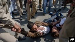 Indian policemen detain Kashmiri Shiite Muslims for participating in a religious procession in central Srinagar, Indian controlled Kashmir, Wednesday, Sept. 19, 2018.