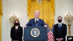 President Joe Biden speaks about the evacuation of American citizens, their families, SIV applicants and vulnerable Afghans in the East Room of the White House, Friday, Aug. 20, 2021, in Washington. Vice President Kamala Harris, left, and Secretary of State Antony Blinken, right,