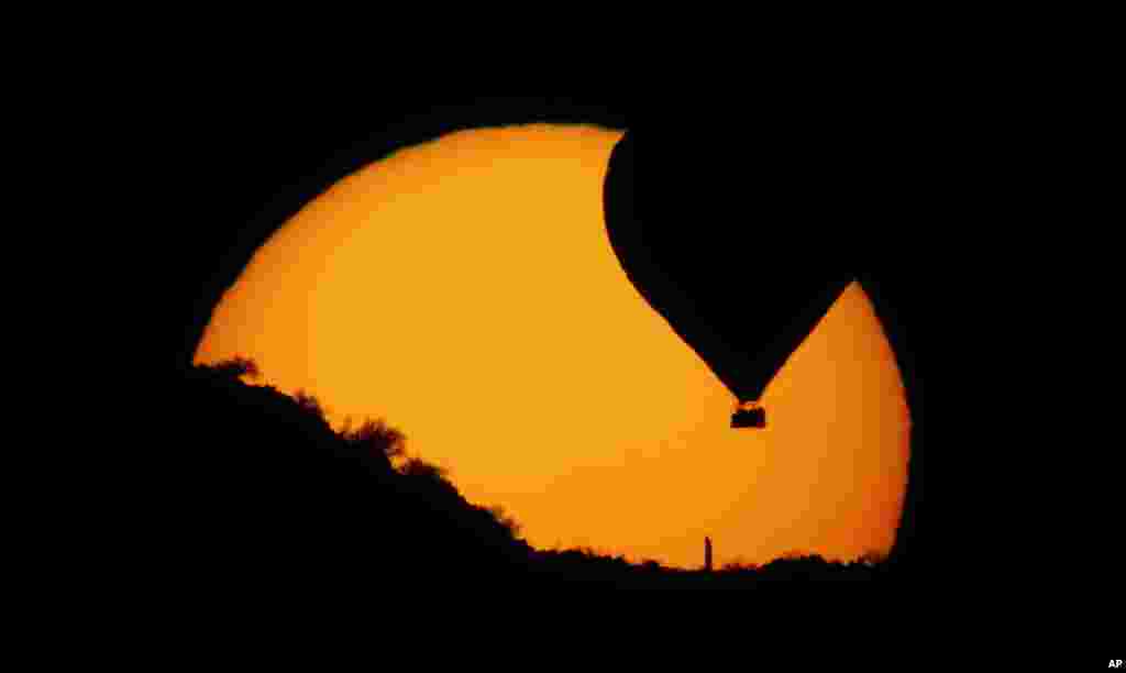 A hot air balloon decends to land as the sun sets north of Phoenix, Arizona, USA, Mar. 1, 2013. 