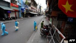 Nhân viên y tế đi lấy mẫu xét nghiệm COVID-19 ở thành phố Hồ Chí Minh (ảnh tư liệu, 9/7/2021).