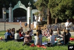 UC 버클리 대학교 새더 게이트 인근에서 학생들이 모여 앉아 있다.