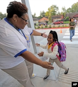 School secretary Demitra Cain, left, greets Tahja Hollerman, 5, for her first day of kindergarten at Codwell Elementary School, Sept. 11, 2017, in Houston.