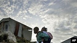 A boy carries a girl to school at a camp for earthquake displaced people in Port-au-Prince, Haiti, Dec 17, 2010.