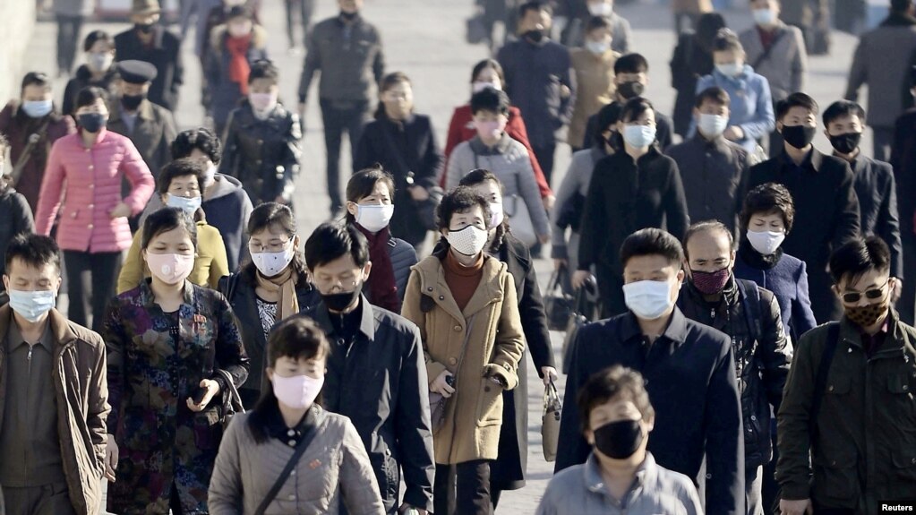 朝鲜首都平壤的人们佩戴口罩预防新冠病毒感染（共同社 /路透社 2020年3月30日）(photo:VOA)