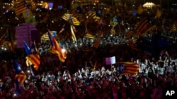 People cheer and wave esteledas, or Catalonia independence flags, during the "Yes" vote closing campaign in Barcelona, Spain, Sept. 29, 2017.