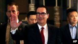 Bộ Trưởng Thương Mại Mỹ Steven Mnuchin, ở giữa, vẫy tay chào các nhà báo khi ông về tới khách sạn sau một cuộc gặp gỡ với các quan chức TQ ở Bắc Kinh hôm 3/5/2018. (AP Photo/Andy Wong)