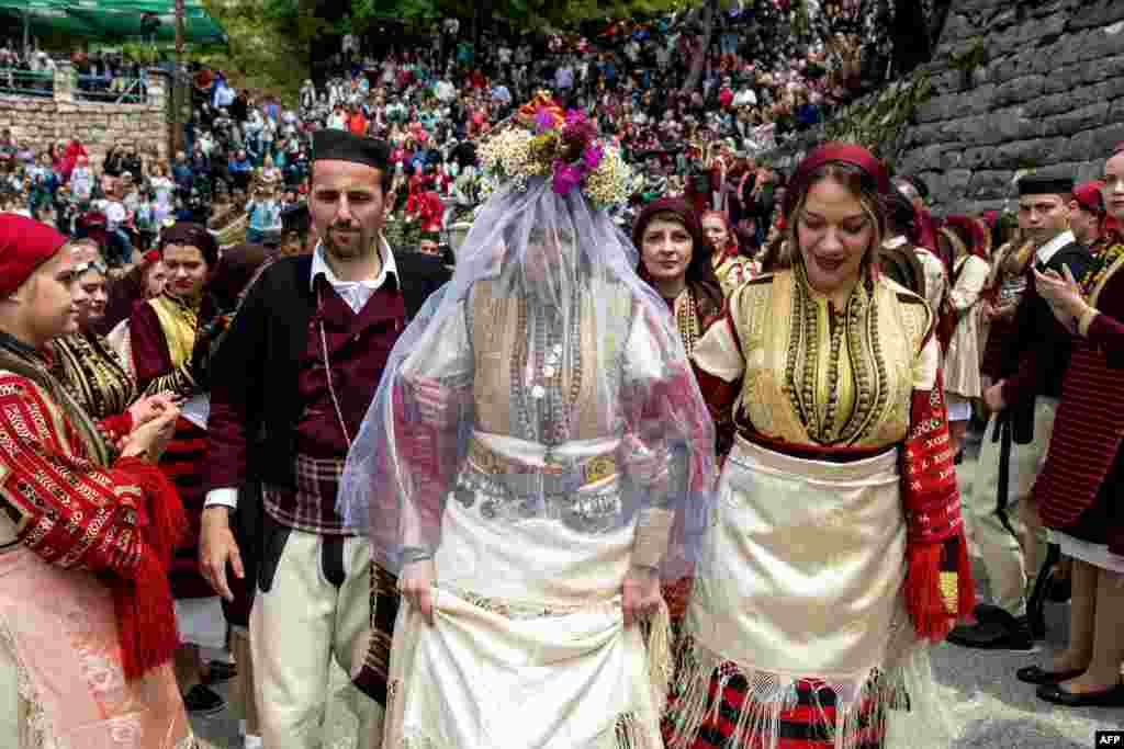 កូន​ក្រមុំ​ម្នាក់​ដើរ​ក្នុង​ពិធី​អាពាហ៍ពិពាហ៍​ប្រពៃណី​មួយ​ ក្នុង​ពិធីបុណ្យ Galicnik Wedding Festival នៅ​ក្នុង​ភូមិ Galicnik ប្រទេស​ម៉ាសេដ្វាន (Macedonia) កាលពី​ថ្ងៃទី១៣ ខែកក្កដា ឆ្នាំ២០១៩។