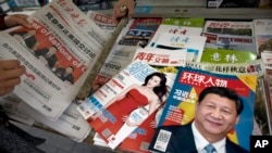 北京報攤上的報紙刊物，其中《環球人物》雜誌的封面上有習近平照片和《習近平中國強起來》的標題，還有報導中共十九大修改黨章消息的北京晚報，也有以影視明星范冰冰為封面的《知音》雜誌。（2017年10月21日）